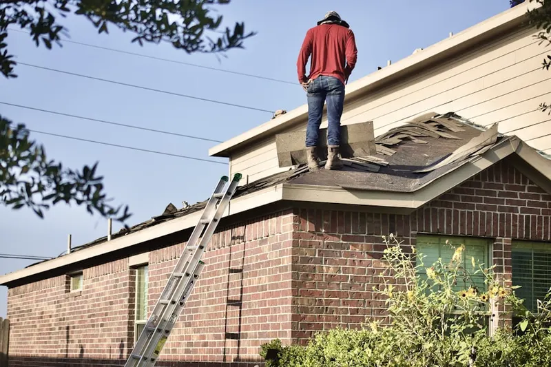 Professional roofer working on a residential roof in Pleasant Ridge